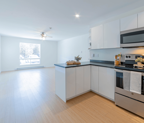 Saint John apartment for rent - A modern kitchen with white cabinets and a wooden floor.