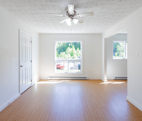 Saint John apartment for rent - A room with a ceiling fan and a window with a view of trees and a red car outside.
