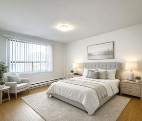 Moncton apartment for rent - A bedroom with a large bed, a nightstand, a chair, and a painting on the wall.
