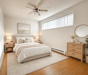 Moncton apartment for rent - A bedroom with a large bed, a ceiling fan, and a nightstand with a lamp.