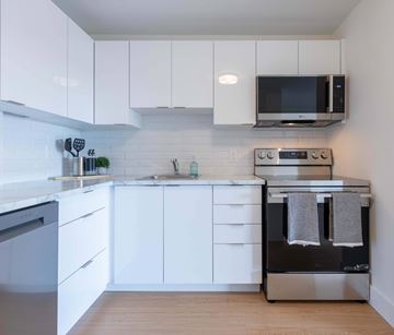 Moncton apartment for rent - A modern kitchen with white cabinets and appliances.