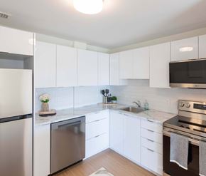Moncton apartment for rent - A modern kitchen with white cabinets and stainless steel appliances.