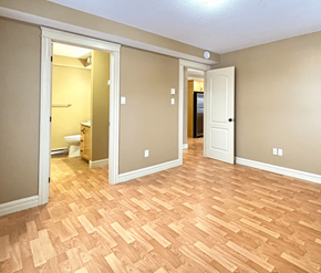 Dieppe apartment for rent - A room with wooden flooring and two doors.