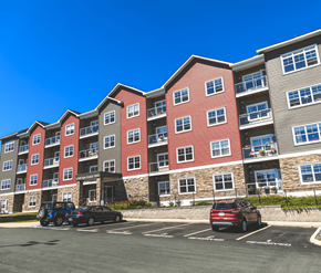 St. Johns apartment for rent - A parking lot in front of a multi-story apartment building with cars parked.
