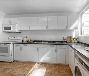 Victoria apartment for rent - A kitchen with white cabinets and appliances, a tiled backsplash, and a wooden floor.