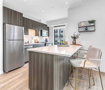 Kitchener apartment for rent - A modern kitchen with a stainless steel refrigerator and a white countertop.