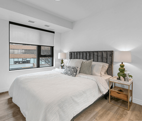 Kitchener apartment for rent - A bedroom with a large bed and a window with blinds.