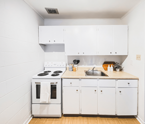 St. Johns apartment for rent - A white kitchen with a stove, sink, and cabinets.