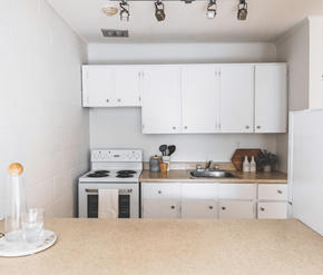 St. Johns apartment for rent - A white kitchen with a stove, sink, and cabinets.
