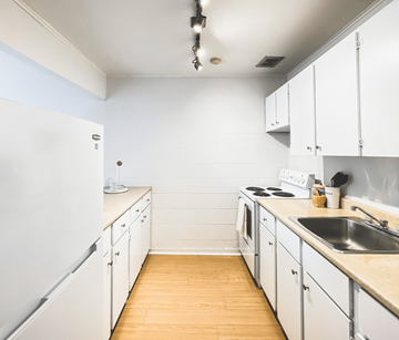 St. John's apartment for rent - A kitchen with white cabinets and a white fridge.