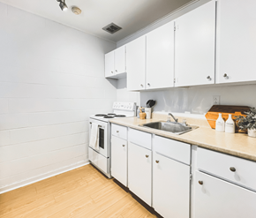 St. Johns apartment for rent - A kitchen with white cabinets and a wooden floor.