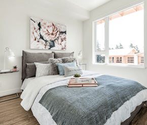 Victoria apartment for rent - A bedroom with a large bed and a floral painting on the wall.