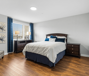 Moncton apartment for rent - A bedroom with a large bed and a wooden floor.