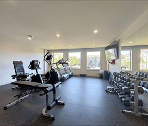 Moncton apartment for rent - A spacious gym with a variety of equipment including treadmills, stationary bikes, and weight machines.
