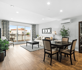 Moncton apartment for rent - A dining room with a table set for four and a balcony with a view of a house.