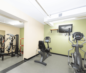 Fredericton apartment for rent - A gym with a treadmill, exercise bike, and a television.