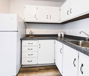 St. John's apartment for rent - A kitchen with white cabinets and a black countertop.