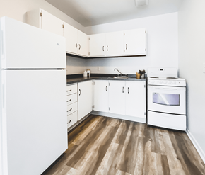 St. Johns apartment for rent - A white kitchen with wood flooring and white appliances.