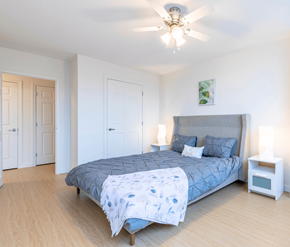 Saint John apartment for rent - A bedroom with a bed, a ceiling fan, and a nightstand.