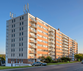 Saint John apartment for rent - A large apartment building with a car parked in front.