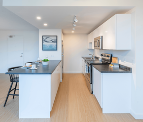 Saint John apartment for rent - A kitchen with white cabinets and a black countertop.