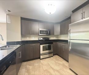 Dieppe apartment for rent - A kitchen with a stove, oven, refrigerator, and microwave.