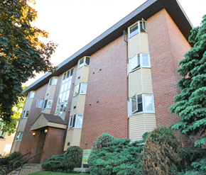Moncton apartment for rent - A red brick building with a balcony on the second floor.