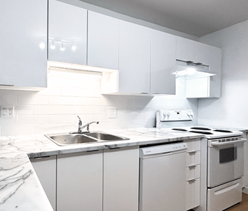 Moncton apartment for rent - A white kitchen with a sink and stove.