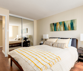 Calgary apartment for rent - A bedroom with a large bed and a painting on the wall.
