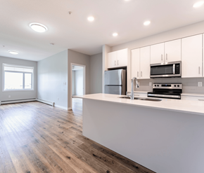Edmonton apartment for rent - A kitchen with a refrigerator, microwave, and oven.