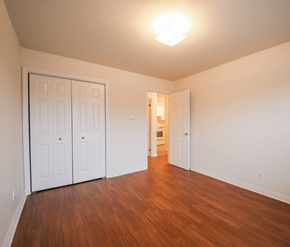 Moncton apartment for rent - A room with white walls and wooden floors has two white doors.