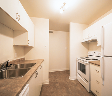 Moncton apartment for rent - A kitchen with white appliances and a brown counter top.