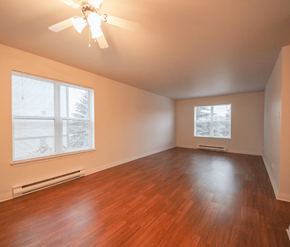 Moncton apartment for rent - A room with a ceiling fan and wooden flooring.