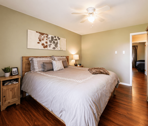 Moncton apartment for rent - A bedroom with a large bed and a ceiling fan.