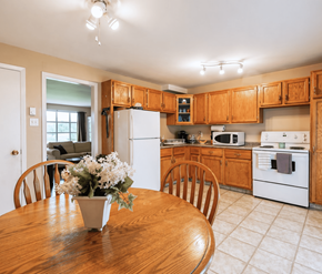 Moncton apartment for rent - A kitchen with wooden cabinets and white appliances.