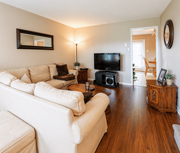 Moncton apartment for rent - A living room with a white couch and a television.