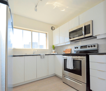 Halifax apartment for rent - A modern kitchen with a stainless steel oven and white cabinets.
