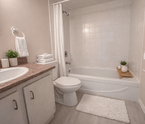 Moncton apartment for rent - A white toilet sits next to a bathtub in a bathroom.