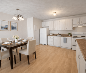 Moncton apartment for rent - A kitchen with a table set for two and a refrigerator.