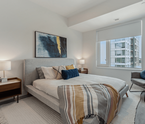 Ottawa apartment for rent - A bedroom with a large bed and a painting on the wall.