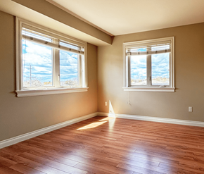 Dieppe apartment for rent - A room with wooden floors and two windows.