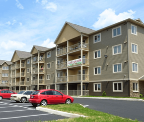 Dieppe apartment for rent - A row of apartment buildings with a red car parked in front.
