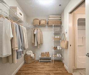 Dieppe apartment for rent - A hallway with a white wall and a white door with a shelf and clothes hanging.