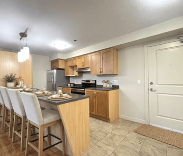 Dieppe apartment for rent - A kitchen with wooden cabinets and a black countertop.