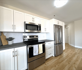 Moncton apartment for rent - A kitchen with white cabinets and stainless steel appliances.