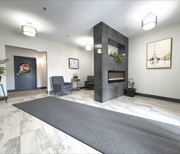 Moncton apartment for rent - A modern living room with a grey rug and a fireplace.