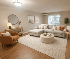 Fredericton apartment for rent - A living room with a brown armchair, a white sofa, and a round ottoman.