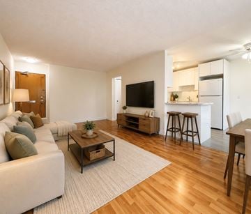 Moncton apartment for rent - A living room with a white couch and a wooden coffee table.