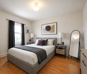 Moncton apartment for rent - A bedroom with a large bed and a wooden floor.