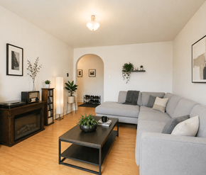 Moncton apartment for rent - A living room with a grey couch, a coffee table, and a fireplace.